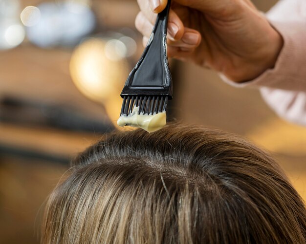 Femme se teindre les cheveux à la maison par un coiffeur