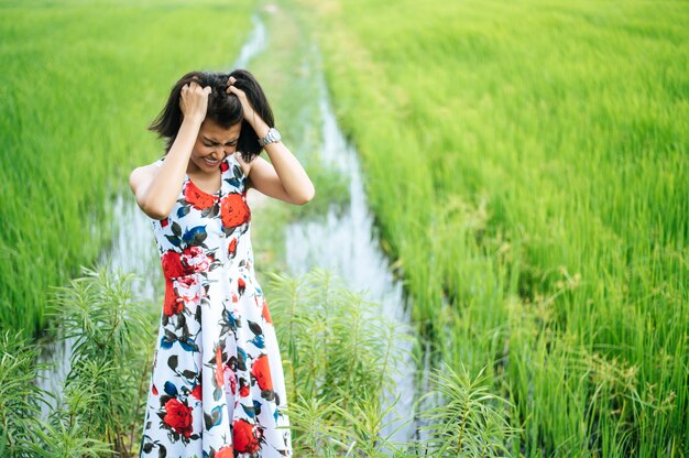 La femme se tenait tendue et la main tenait ses cheveux dans le pré