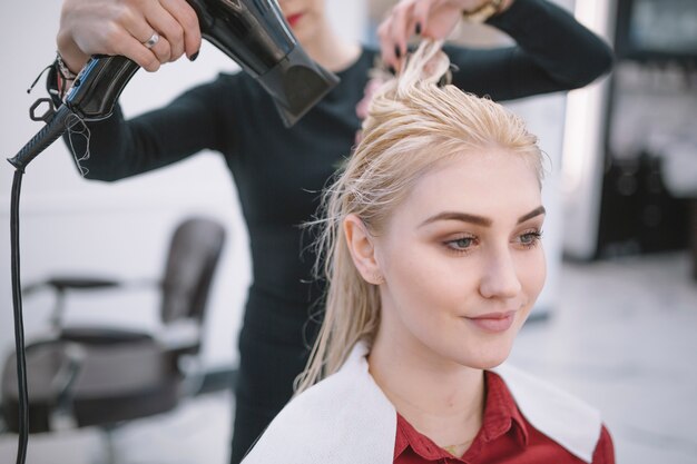 Femme séchant les cheveux mouillés de blonde