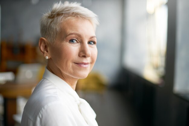 Femme senior expressive posant à l'intérieur