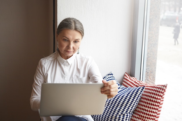 Femme senior expressive posant à l'intérieur