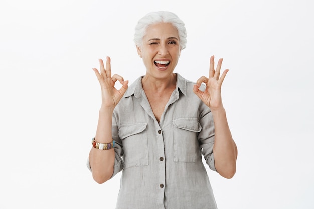 Femme Senior Heureuse Souriante Montrant Un Geste Correct Et Un Clin De œil, Louange Un Excellent Choix