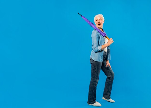 Femme senior moderne avec parapluie