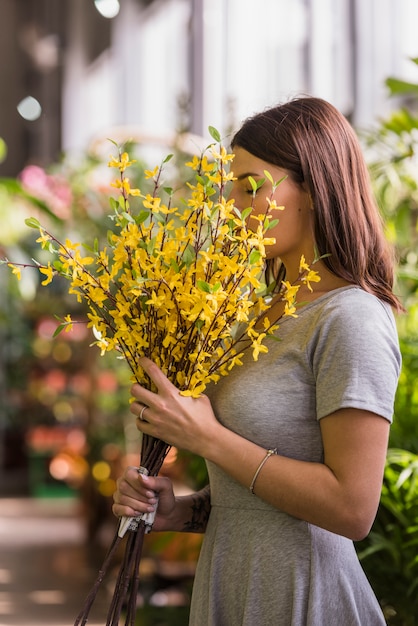 Femme sentant les fleurs jaunes
