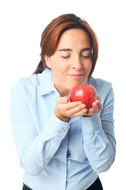 Femme sentant une pomme rouge