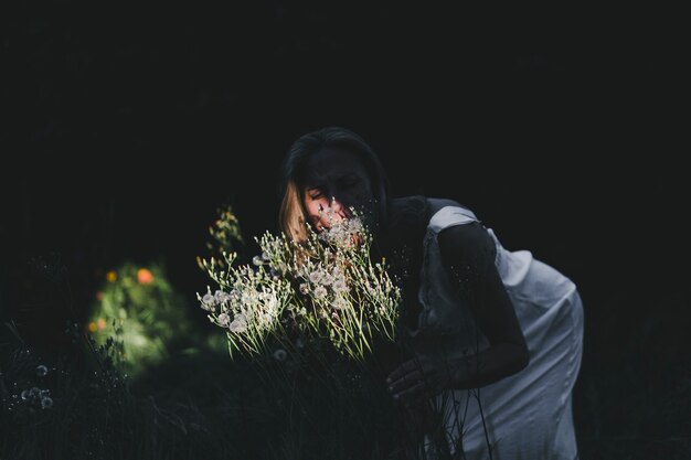 Femme, sentir, champ, fleurs