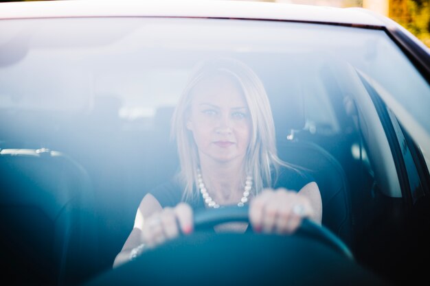 Femme sérieuse adulte en voiture