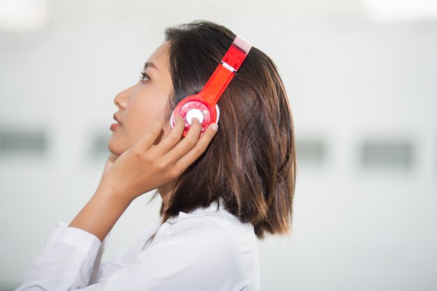 Femme sérieuse dans un casque d&#39;écoute de la musique