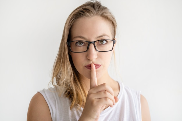 Photo gratuite femme sérieuse faisant un geste du silence et regardant la caméra