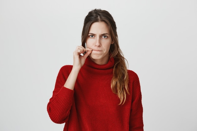 Femme sérieuse zipping bouche, gardez le secret