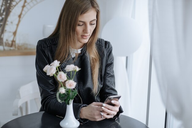 Femme avec sérieux typage visage sur son téléphone intelligent