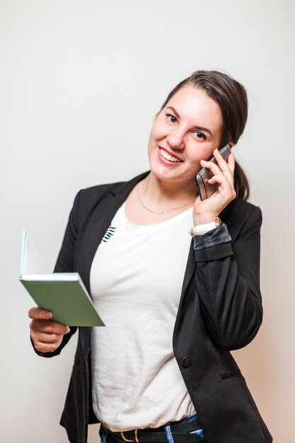 Femme avec smartphone et bloc-notes