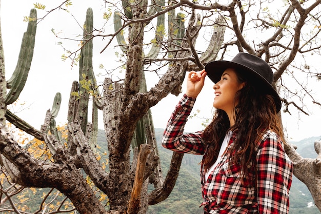 Photo gratuite femme smiley faible angle avec un chapeau dans la nature
