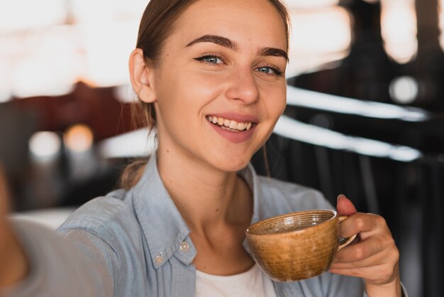 Femme smiley grand angle, boire du café