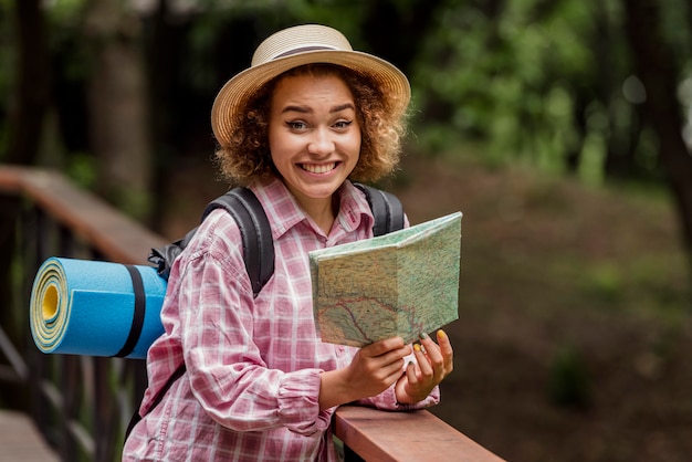 Femme Smiley vérifiant une carte pour une nouvelle destination