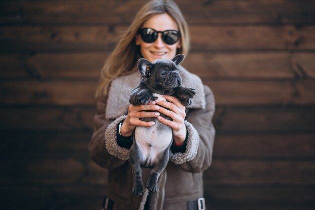 Femme avec son bouledogue français sur fond en bois