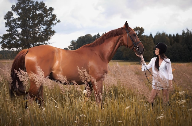 Femme avec son cheval brun.