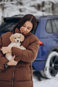 Femme avec son chien mignon par la voiture