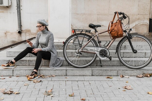 Femme et son vélo assis sur les escaliers