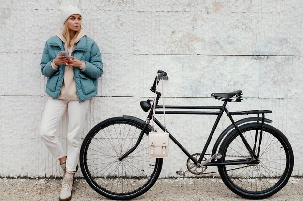 Femme avec son vélo en prenant une pause long shot