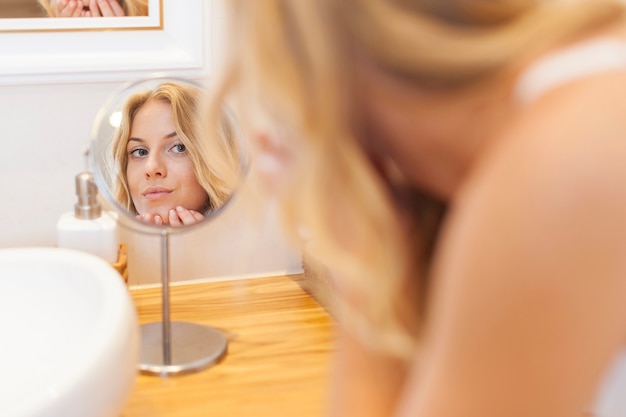 Femme Soucieuse De Sa Peau Sur Le Visage Devant Un Petit Miroir