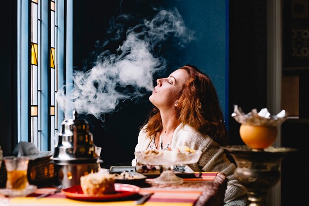 Femme, souffler, fumée, narguilé, restaurant