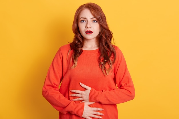 Femme souffrant de maux d'estomac, ayant une intoxication alimentaire, posant isolé,