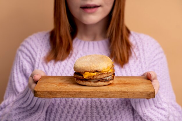 Femme souffrant de troubles de l'alimentation essayant de manger un hamburger