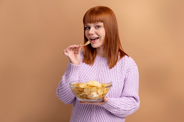 Femme souffrant de troubles de l'alimentation mangeant des chips