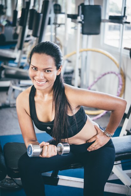 Femme soulever un haltère avec un bras