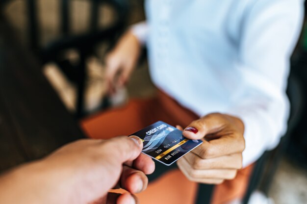 Femme soumettant une carte de crédit pour payer des biens