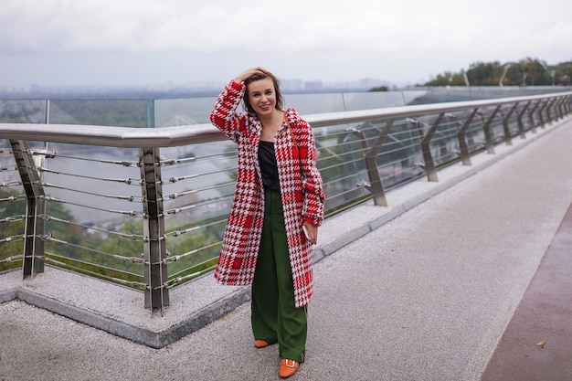 Une femme souriante d'âge moyen portant des vêtements d'automne.