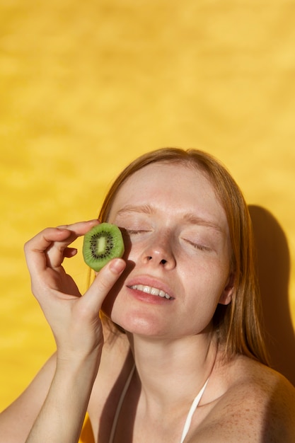 Photo gratuite femme souriante à angle élevé avec h kiwi