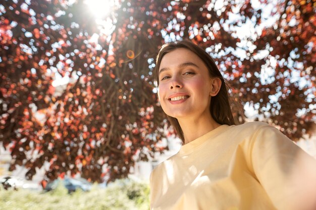 Femme souriante angle faible posant