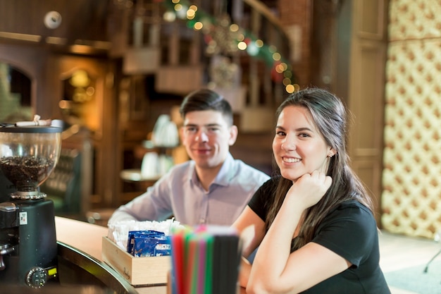 Femme souriante assise au comptoir près de l&#39;homme