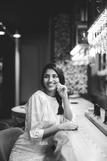 Femme souriante assise au comptoir