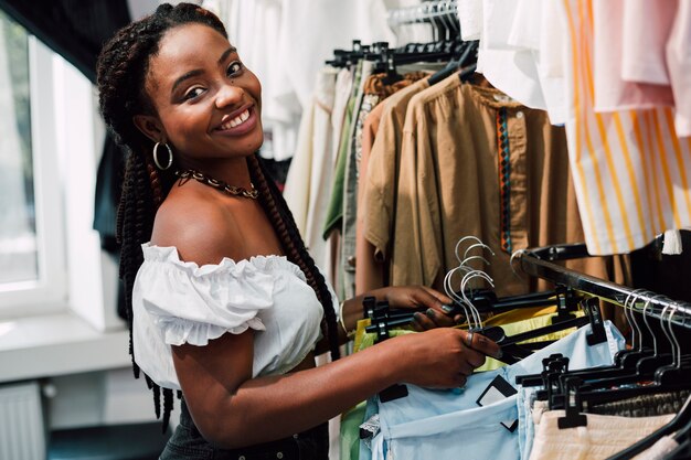 Femme souriante au shopping dans un magasin de vêtements