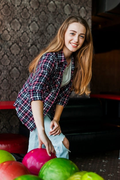Femme souriante avec des boules de bowling colorées