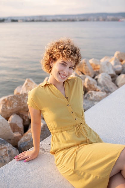 Photo gratuite femme souriante de coup moyen au bord de la mer