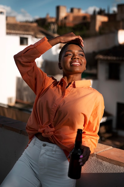 Photo gratuite femme souriante à coup moyen avec une bouteille