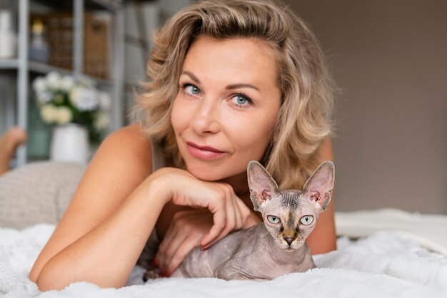 Femme souriante de coup moyen caressant un chat mignon