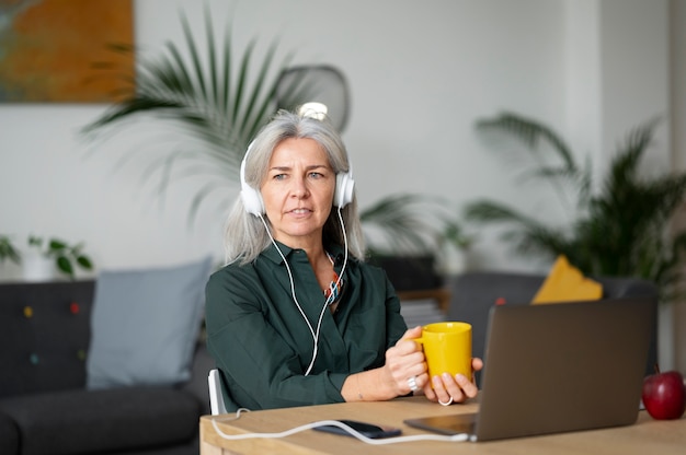 Femme souriante à coup moyen avec un casque au bureau