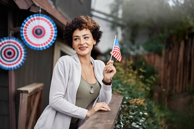 Femme souriante à coup moyen célébrant avec le drapeau