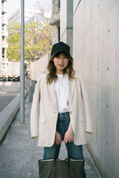 Femme souriante à coup moyen avec chapeau de camionneur et sac