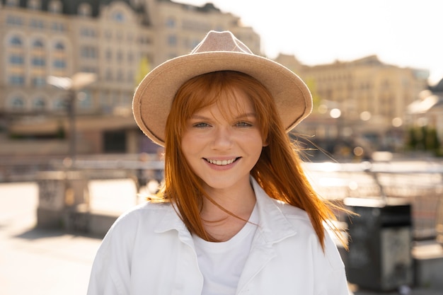 Femme souriante de coup moyen avec un chapeau