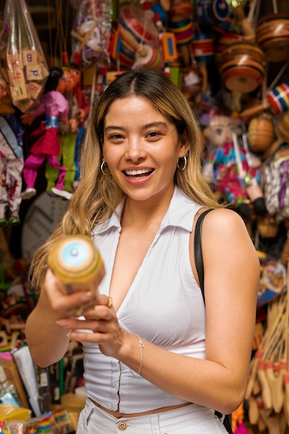 Photo gratuite femme souriante à coup moyen dans une boutique de souvenirs