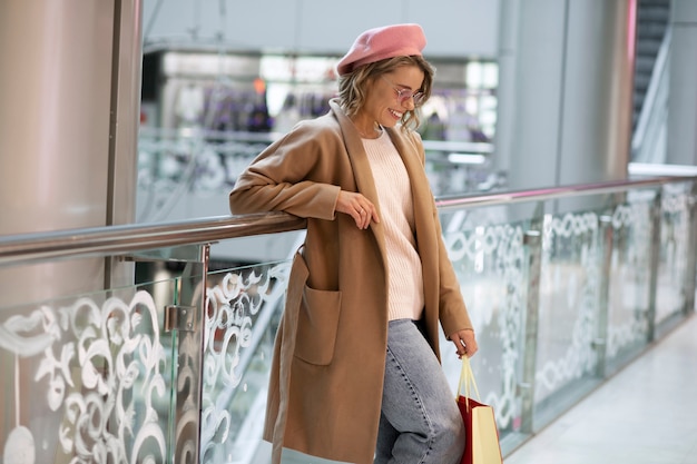 Femme souriante à coup moyen dans un commerce de détail local