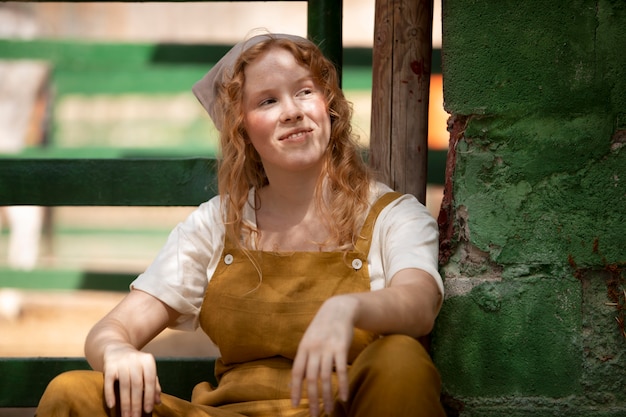 Femme souriante de coup moyen à la ferme