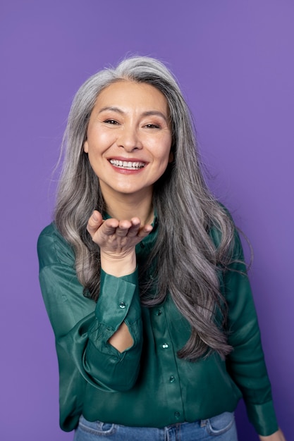 Photo gratuite femme souriante à coup moyen avec un fond violet