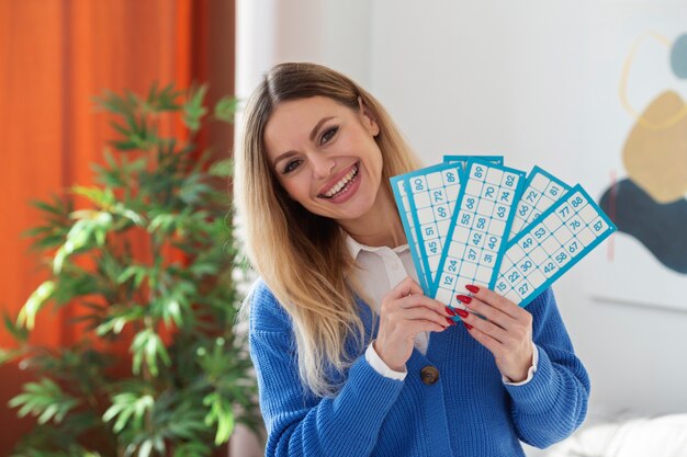 Femme souriante de coup moyen gagnant des jeux de bingo